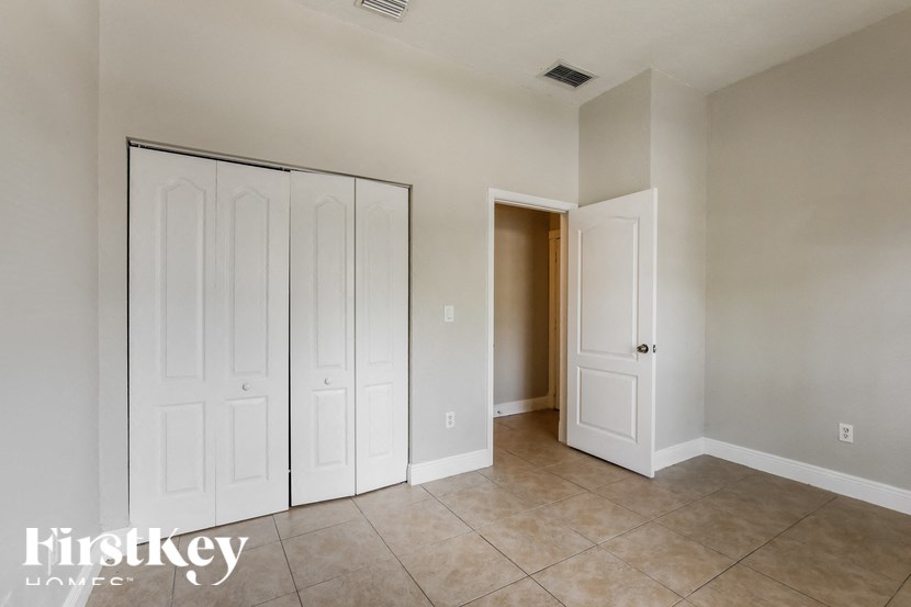 a master bedroom with two closets and a tiled floor