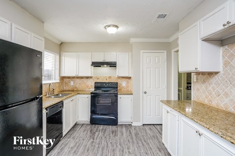 A kitchen with a black fridge and a black oven.