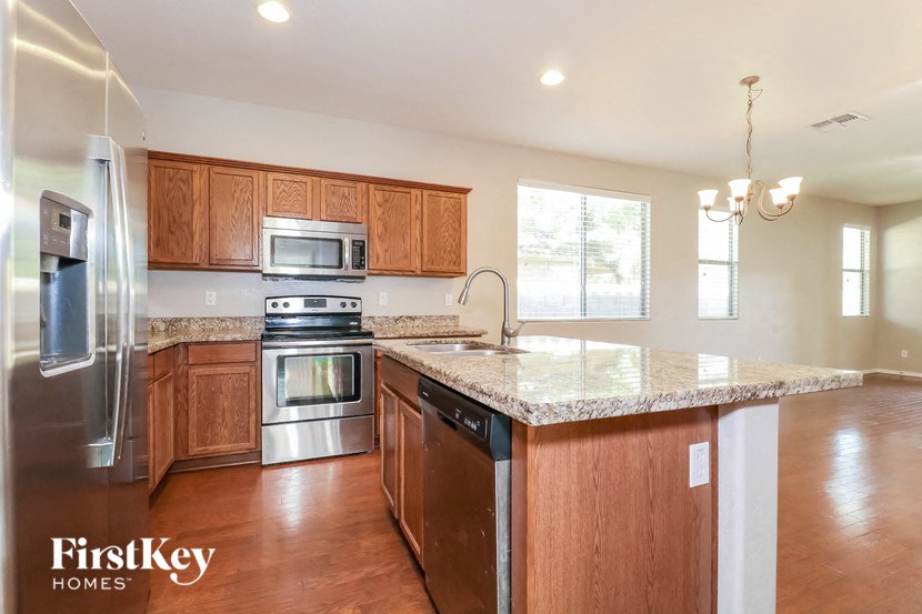 a kitchen with wooden cabinets and granite counter tops and stainless steel appliances