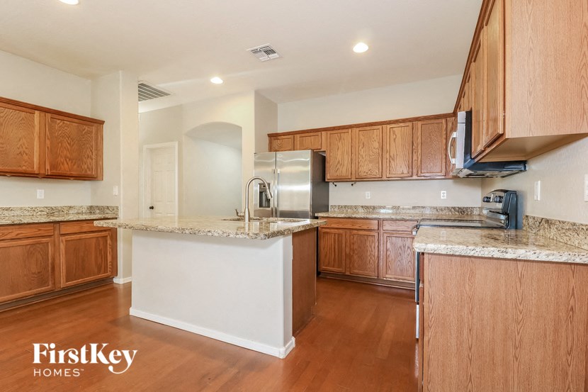 a kitchen with wooden cabinets and granite counter tops and a sink
