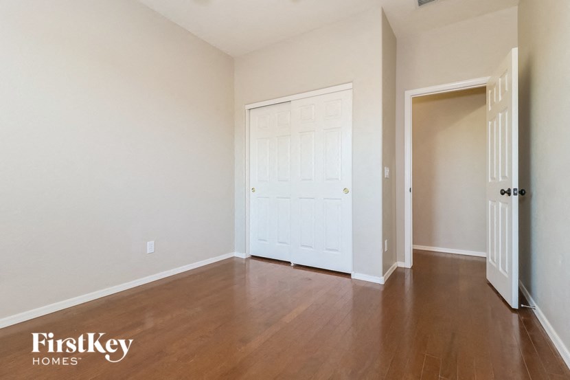 an empty living room with a white door and wood floors