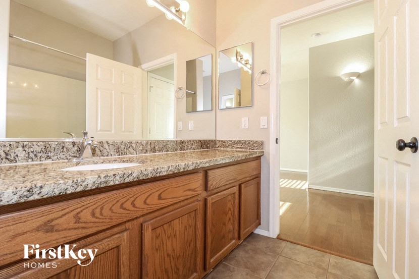 the master bathroom has a large vanity and a large mirror