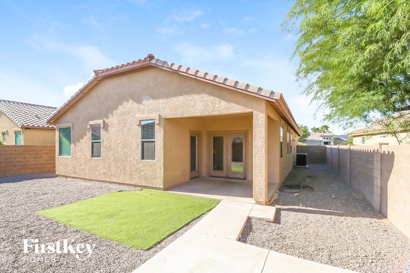 a brown house with a yard and a fence