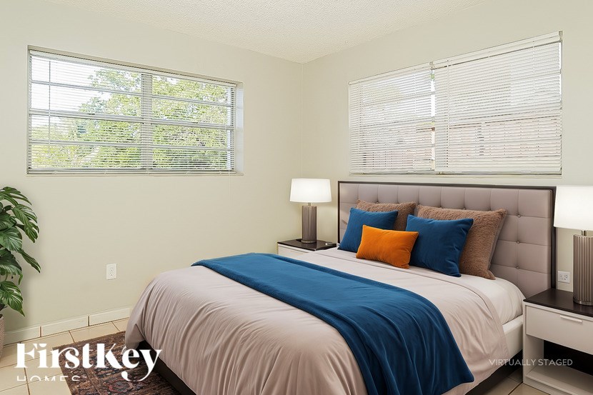 A bedroom with a bed, pillows, and a lamp.
