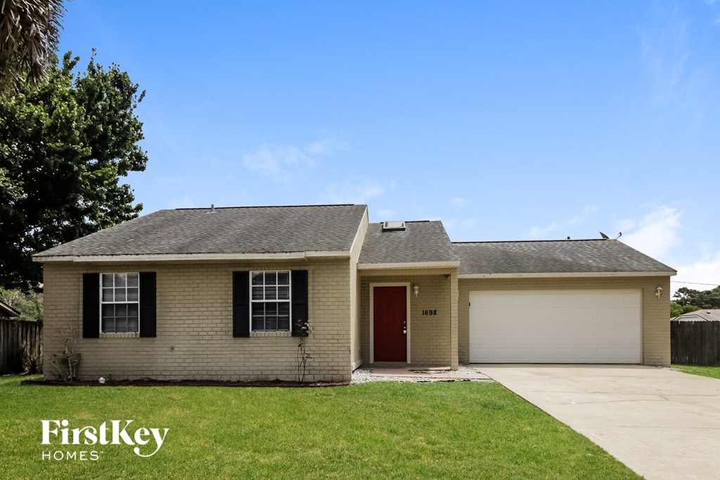 A house with a red door and a garage door is for sale.