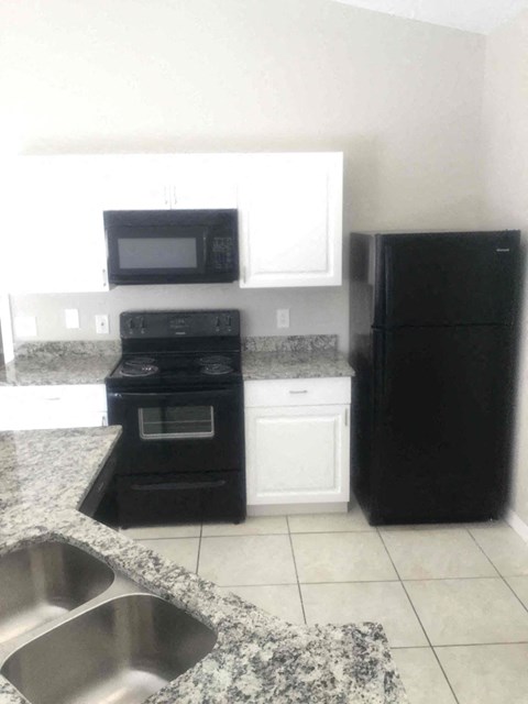 a kitchen with black appliances and white cabinets
