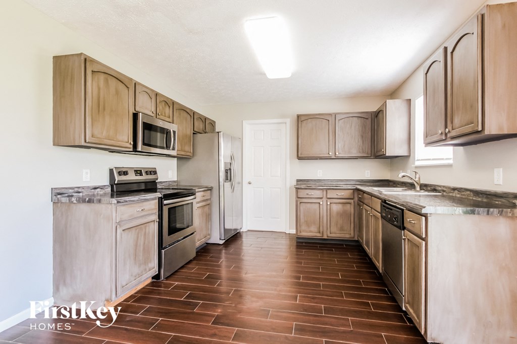 a kitchen with wooden cabinets and stainless steel appliances