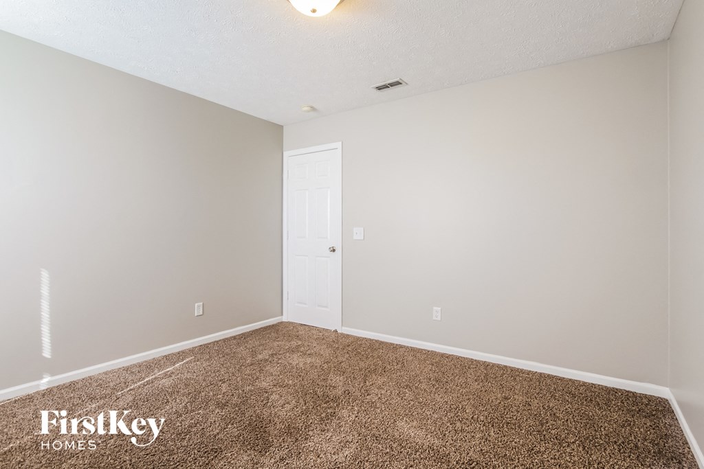 the spacious living room with carpeting and a white door