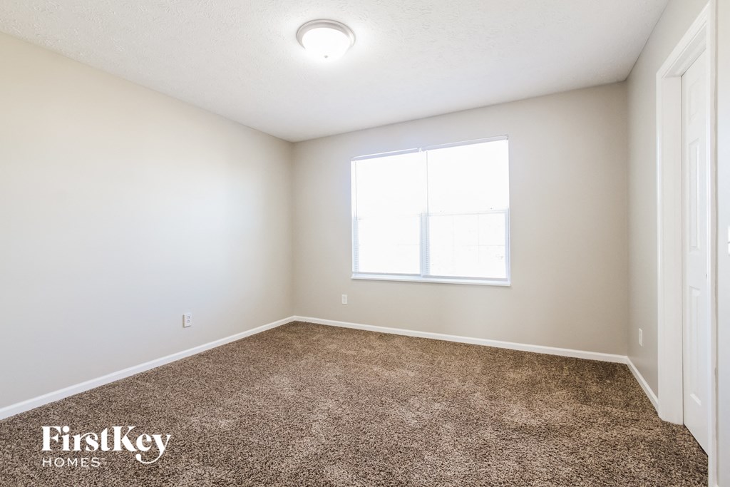 an empty room with carpet and a window