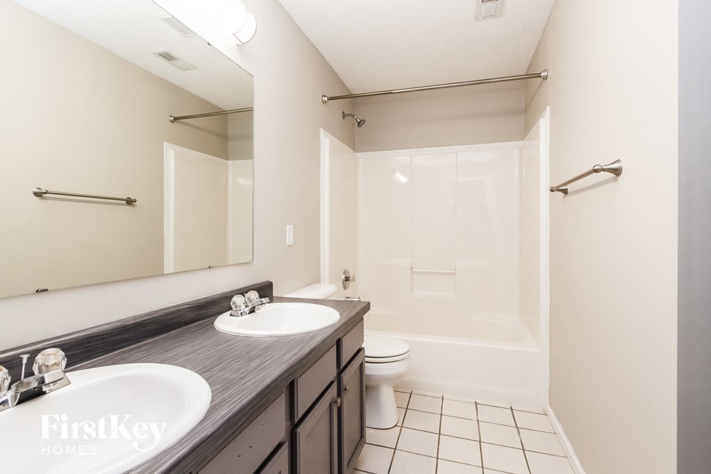 a bathroom with two sinks and a shower and a toilet