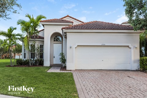 a white house with a white garage door and a lawn