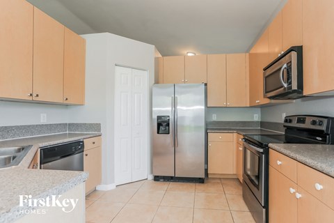 a kitchen with wooden cabinets and stainless steel refrigerator
