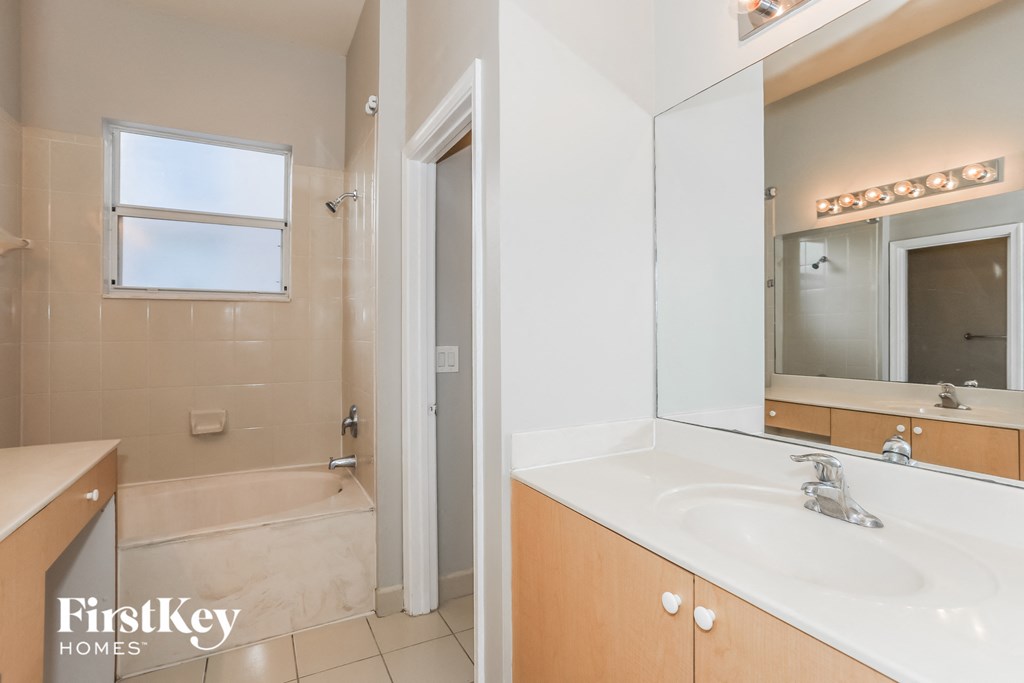 a bathroom with a sink and a shower and a mirror