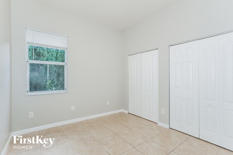 a bedroom with two closets and a tiled floor and two doors