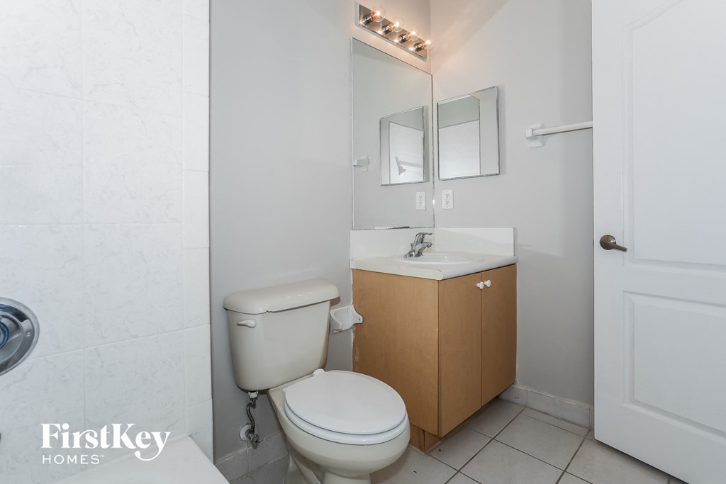 a bathroom with a toilet and a sink and a mirror