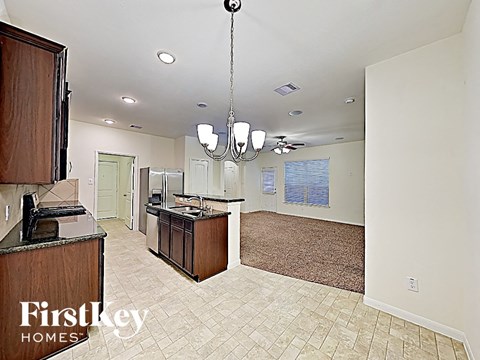 A kitchen area with a brown counter and a chandelier hanging from the ceiling.