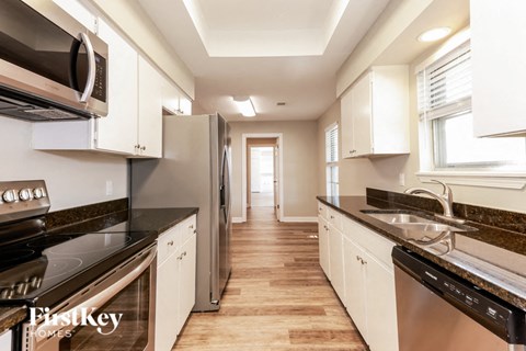 A kitchen with white cabinets and stainless steel appliances.