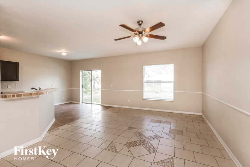 A spacious room with a ceiling fan and tiled floor.