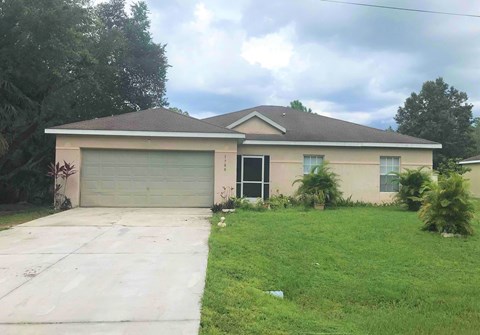 A house with a grey garage door and a brown roof.