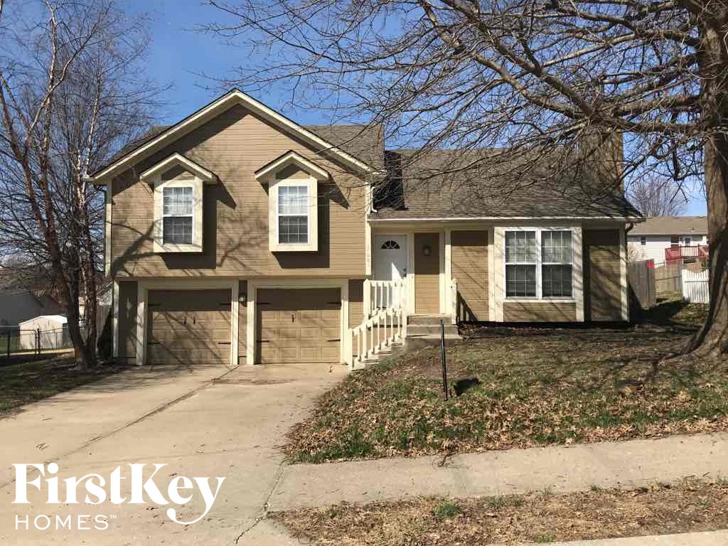 A house with a brown roof and a white picket fence.