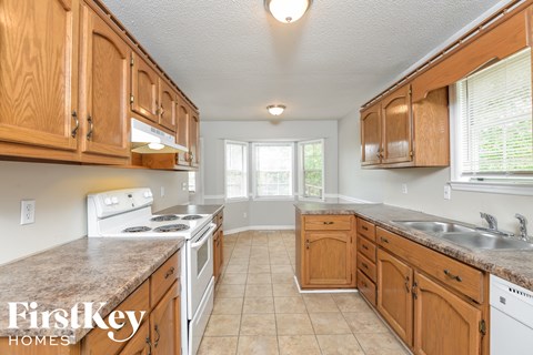 A kitchen with wooden cabinets and a stove top oven.