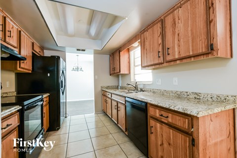 A kitchen with wooden cabinets and black appliances.