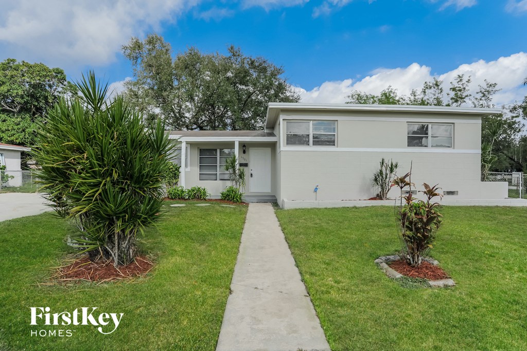 a white house with a lawn and a sidewalk