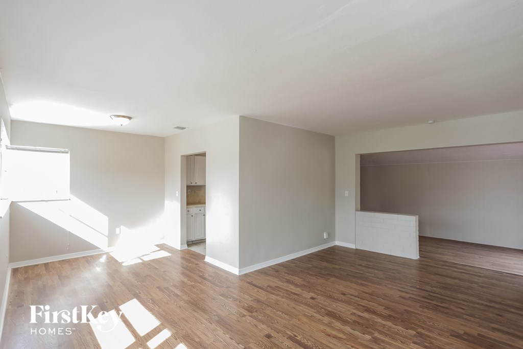 an empty living room with white walls and wood floors