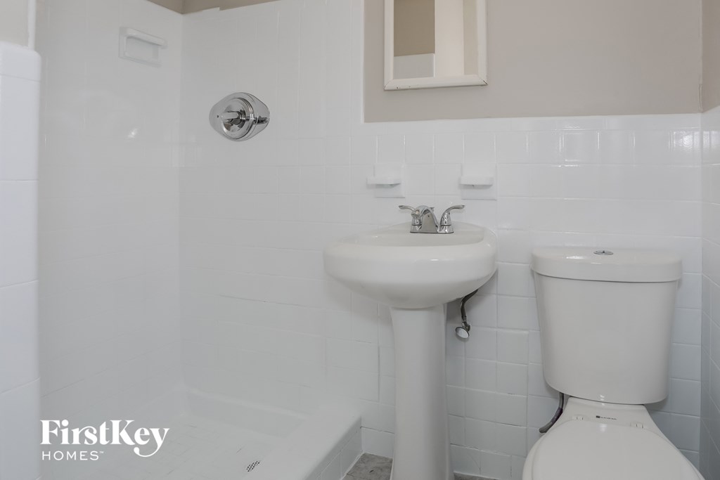 a white bathroom with a sink and a toilet