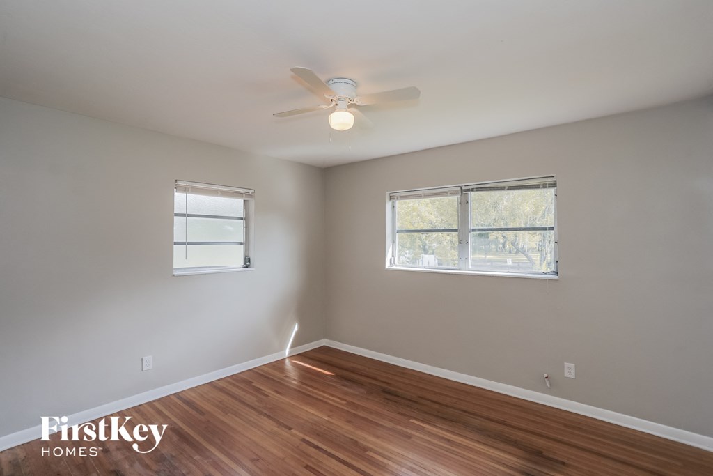 a living room with wood floors and a ceiling fan