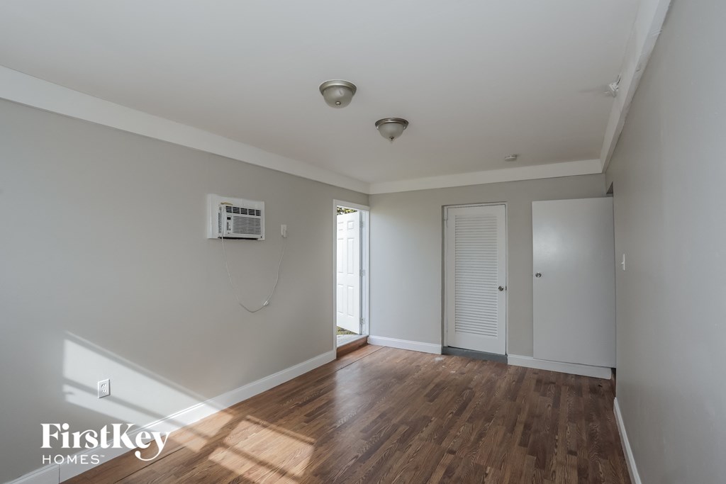 a living room with a hard wood floor and white walls