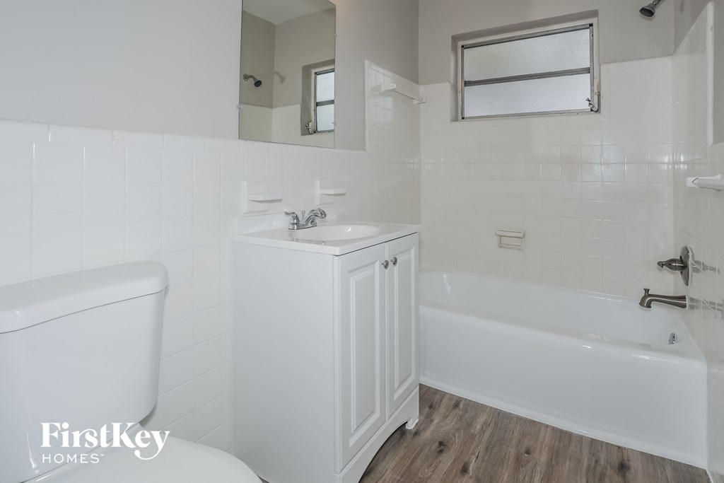 a white bathroom with a tub and sink and a toilet