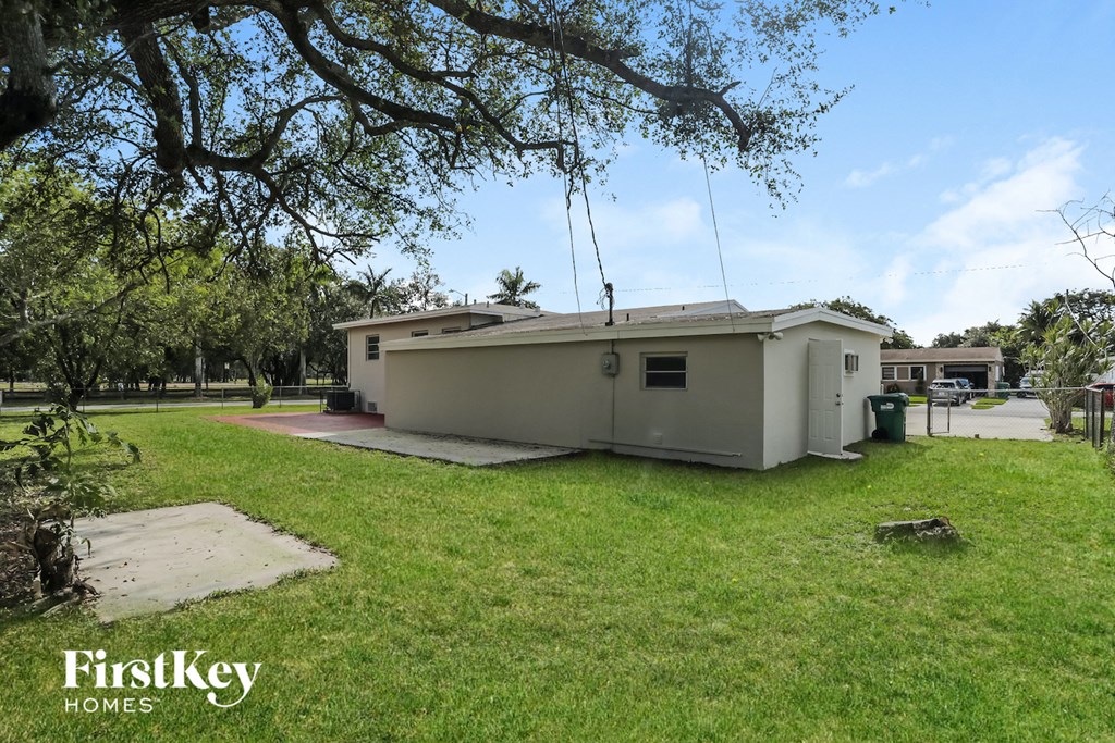 a small house with a yard and a tree