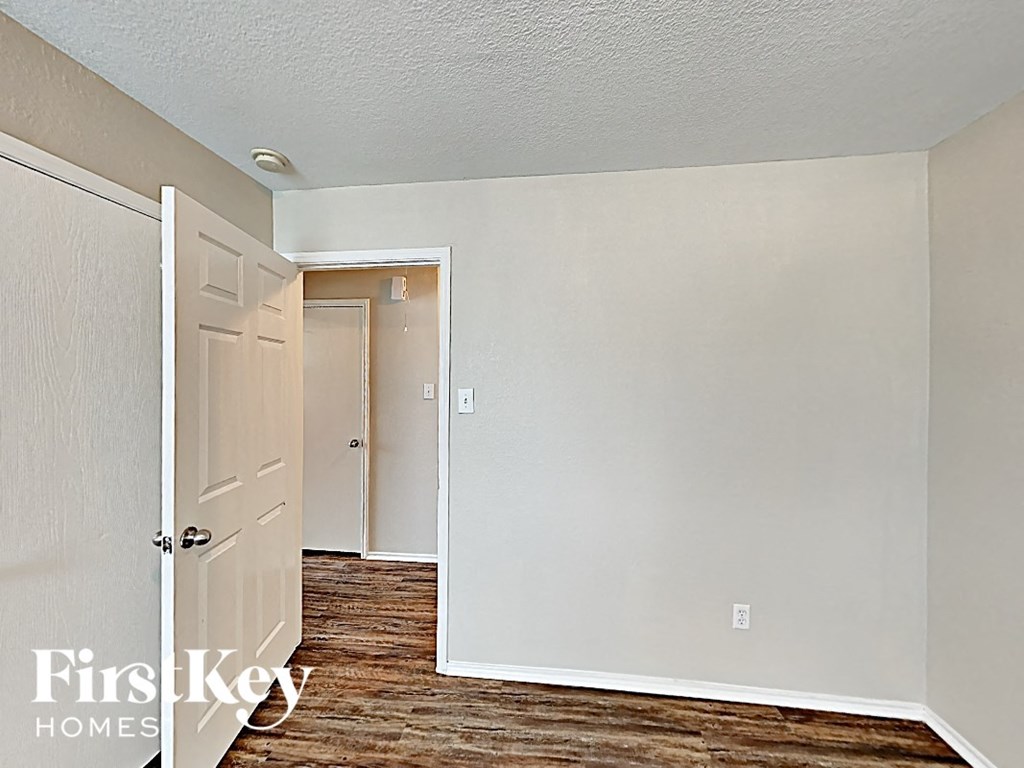 a bedroom with white walls and a door to a closet