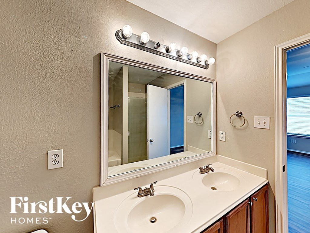a bathroom with two sinks and a large mirror