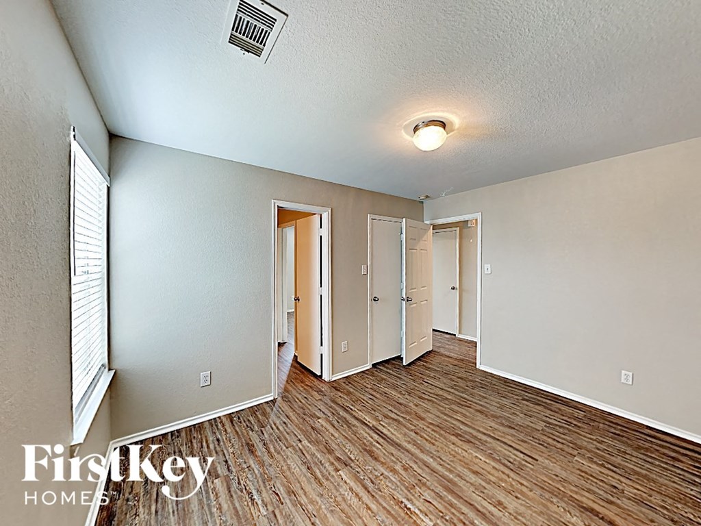 a living room with a hard wood floor and a door to a closet