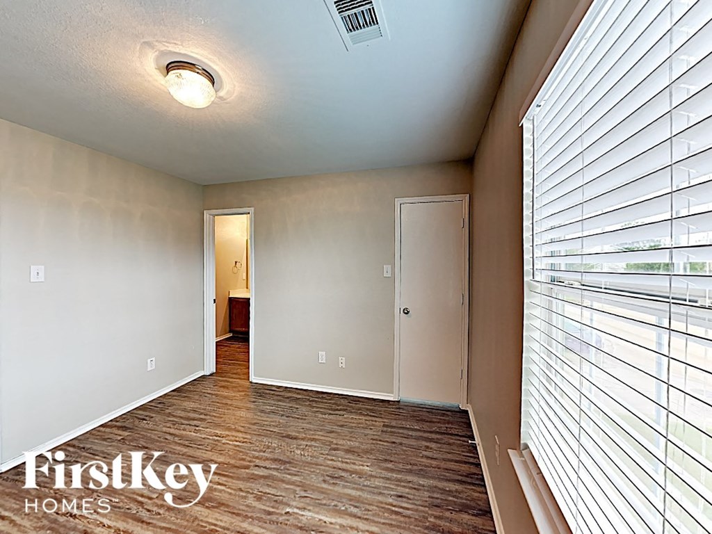 a living room with a large window and a door to a hallway