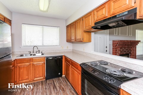 A kitchen with wooden cabinets and a black stove top oven.