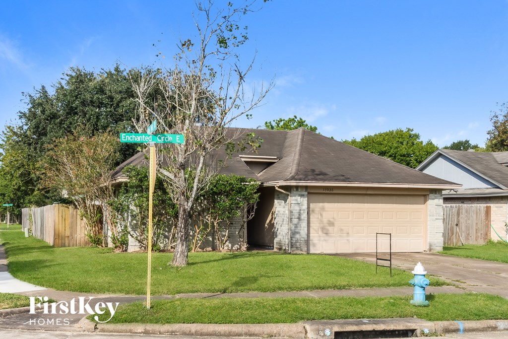 a house with a street sign and a fire hydrant in the grass