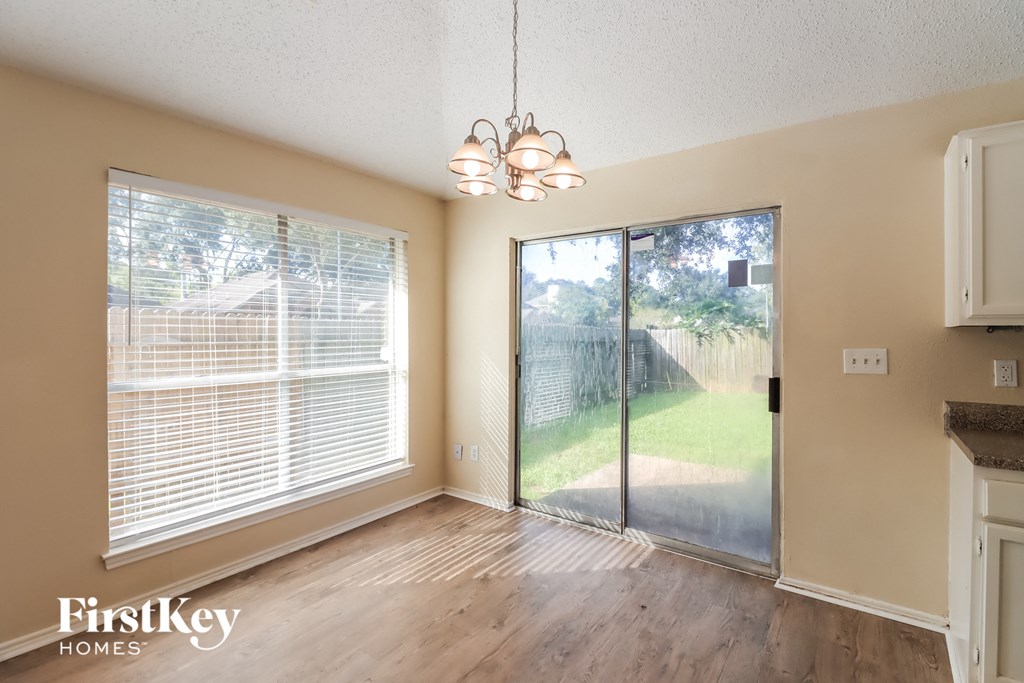 an empty dining room with a sliding glass door to the backyard