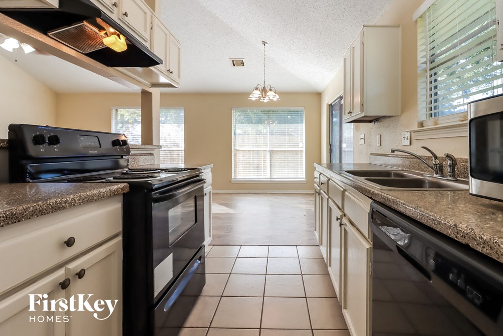 a kitchen with granite counter tops and black appliances