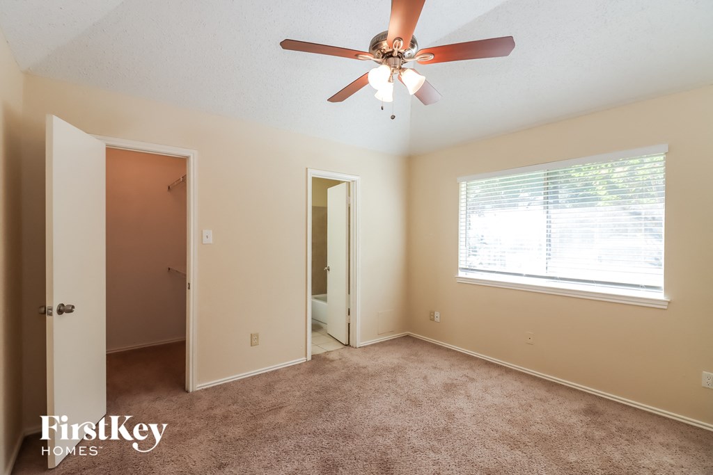 a bedroom with a ceiling fan and a door to a closet