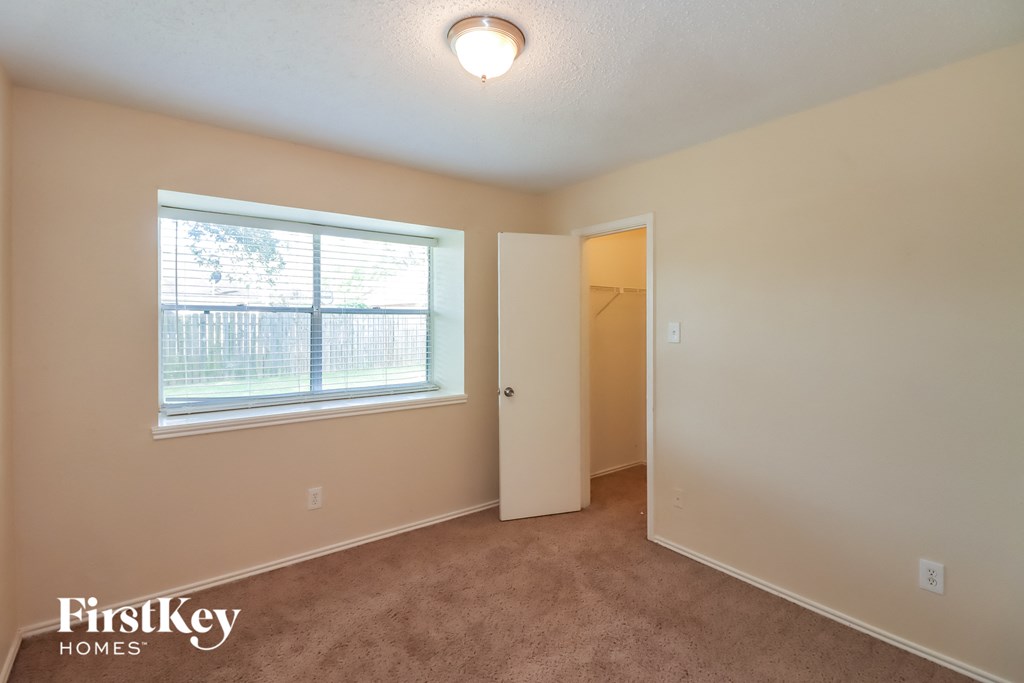 a bedroom with a large window and a door to a closet
