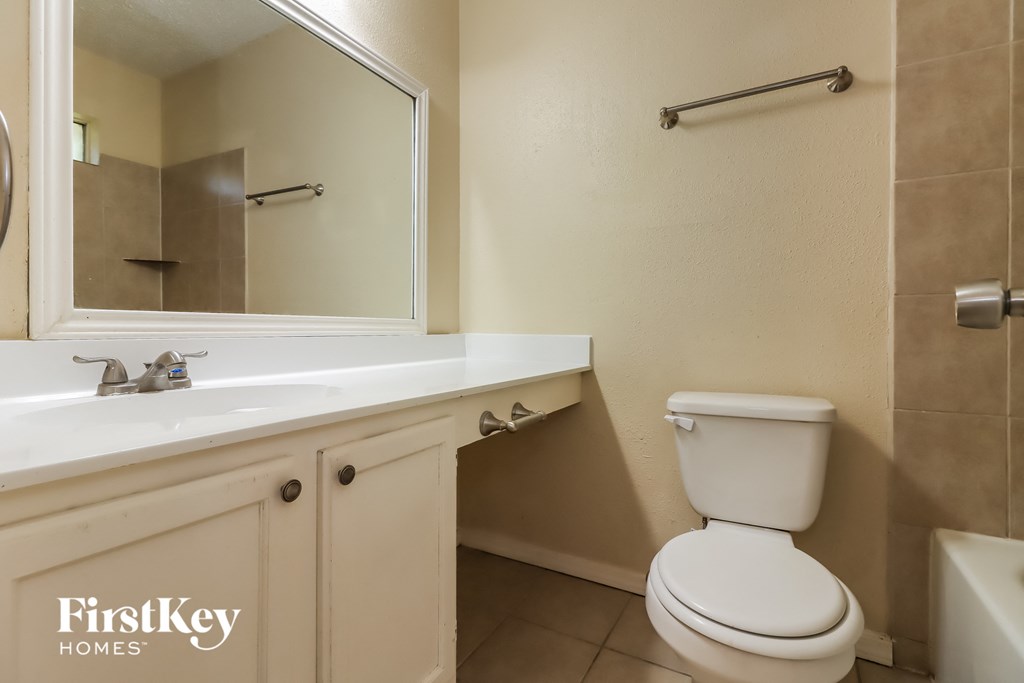 a bathroom with a toilet and a sink and a mirror