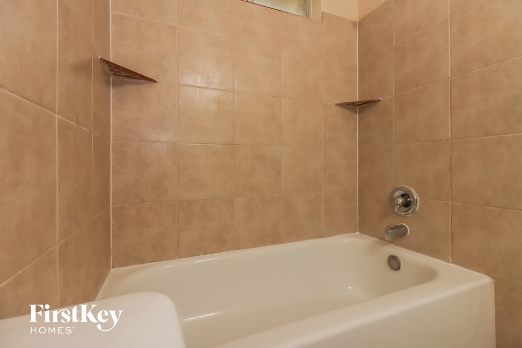 a white bath tub in a tiled bathroom