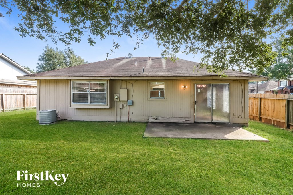 a small white house with a yard and a backdoor