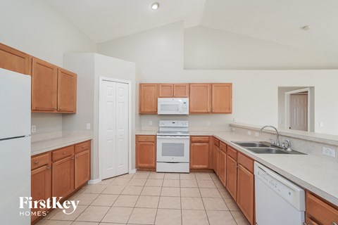 a kitchen with wooden cabinets and white appliances