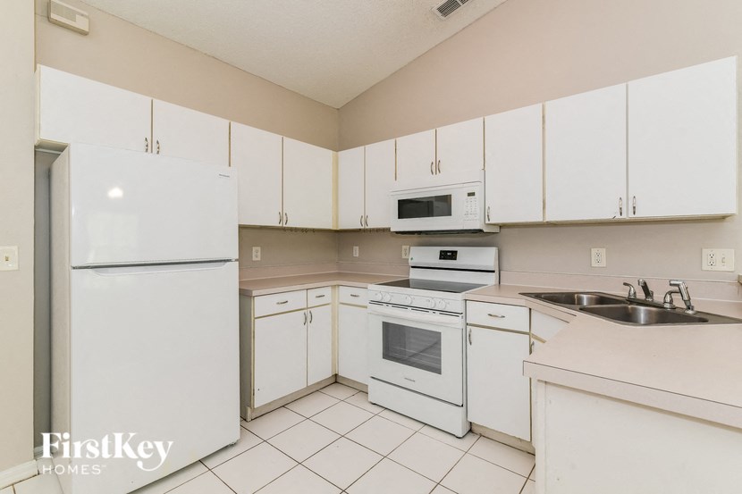 a white kitchen with white appliances and white cabinets