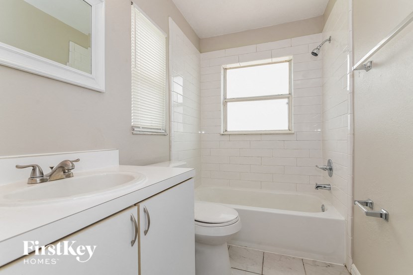 a white bathroom with a sink toilet and tub