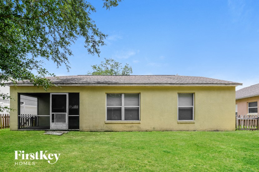 a small yellow house with a lawn and a tree
